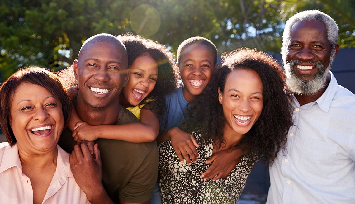 Three generations of a family outdoors, smiling together
